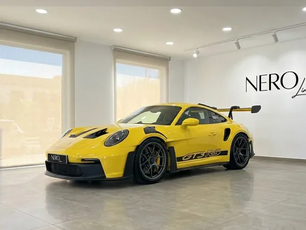 سيارة بورش 911 GT3 RS صفراء لامعة متوقفة في صالة عرض تحمل شعار نيرو لاين على الحائط في إيبيزا.