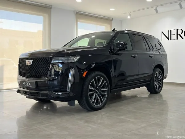 El Cadillac Escalade negro de 2024 se exhibe desde una vista frontal tres cuartos dentro de un luminoso showroom en Barcelona.