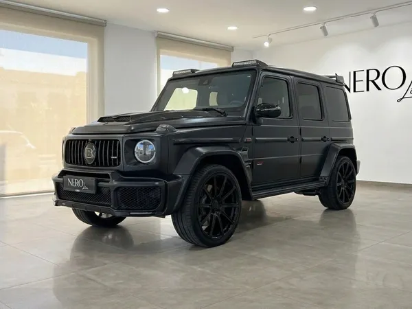 マットブラックのメルセデス・ベンツ G63 800 BRABUSが、イビサの大きな窓があるショールームに展示されています。