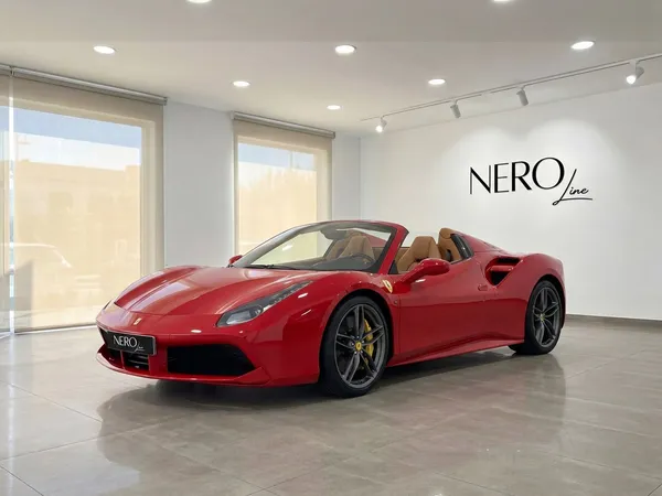 The red Ferrari 488 Spider convertible is showcased in a modern showroom in Mallorca, featuring its open top and luxurious tan interior.