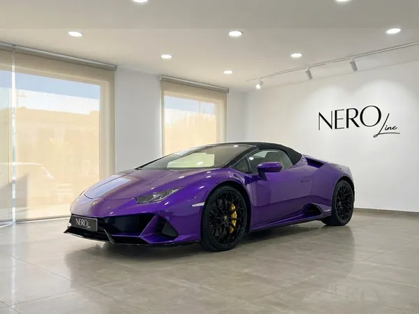 鮮やかな紫色のランボルギーニ ウラカン EVO スパイダー コンバーチブルが、イビサの明るいショールームにNero Lineのロゴと共に駐車されています。