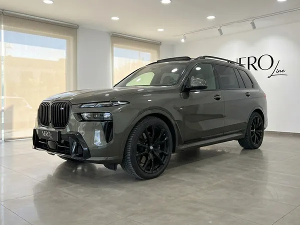 짙은 회색 BMW X7 SUV, 전면 4분의 3 모습, 알리칸테의 현대적인 쇼룸에 주차되어 있습니다.