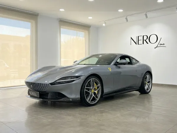 The metallic gray 2022 Ferrari Roma is showcased from a front three-quarter angle in a bright showroom in Madrid.