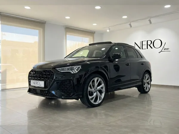 The 2022 black Audi RS Q3 performance SUV is showcased from a front three-quarter angle in a bright Alicante showroom.