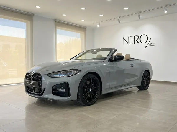 메탈릭 브루클린 그레이 BMW 420d 카브리올레가 지붕을 열고 베이지색 실내와 함께 마르베야 쇼룸에 전시되어 있습니다.