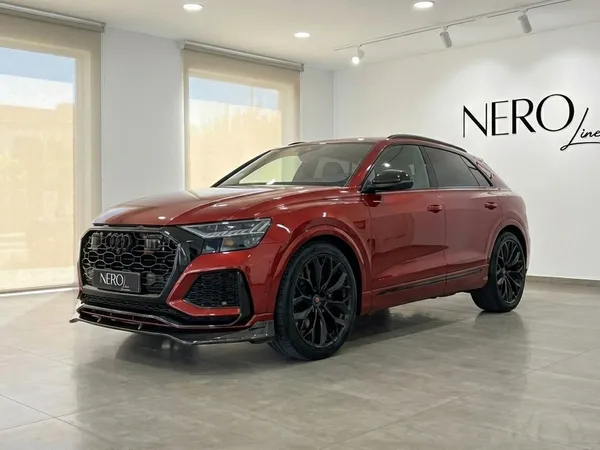 Audi SQ8 with RSQ8 body kit, a metallic red performance SUV, parked in a showroom in Alicante.