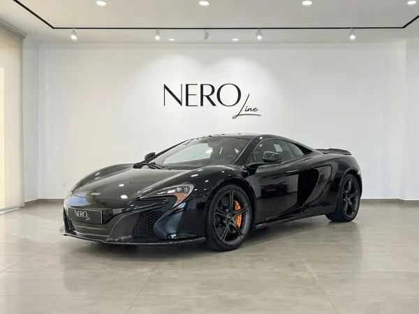 黒いマクラーレン650S MSOスーパーカーがマドリードのショールームに、前方3クォーターアングルで駐車されています。
