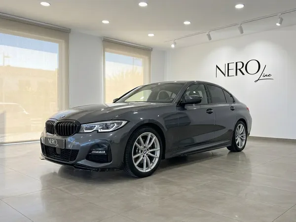 짙은 회색 BMW 320d가 알리칸테의 밝은 쇼룸에서 전면 4분의 3 각도로 전시되어 있습니다.