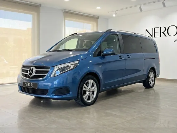 메탈릭 블루 메르세데스-벤츠 V-Class 300d 익스트라롱이 실내에 주차되어 있으며, 마요르카에서 우아한 전면 쿼터 뷰를 선보입니다.