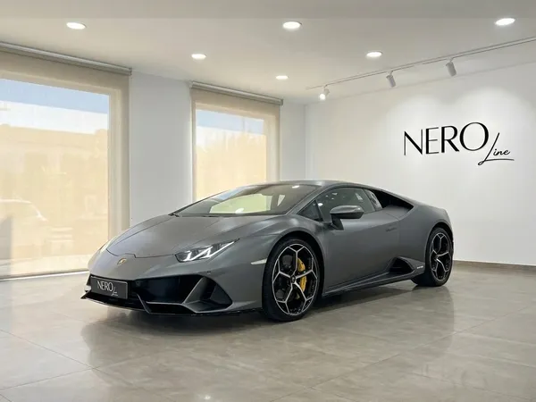 マットグレーのランボルギーニウラカンEVOが、マヨルカの明るいショールームにNEROlineのロゴと共に駐車されています。