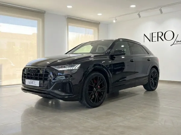 The black Audi Q8 S-line is showcased from a front three-quarter angle in a bright showroom in Marbella.