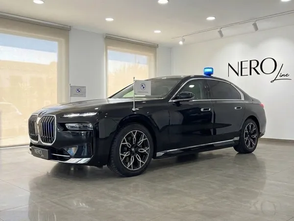 黒いBMW 7 Protectionがマドリードのショールームに展示されており、青いルーフライトとボンネットに旗が付いています。
