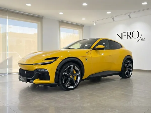 The striking yellow Ferrari Purosangue is showcased from a front three-quarter view inside a modern showroom in Alicante.