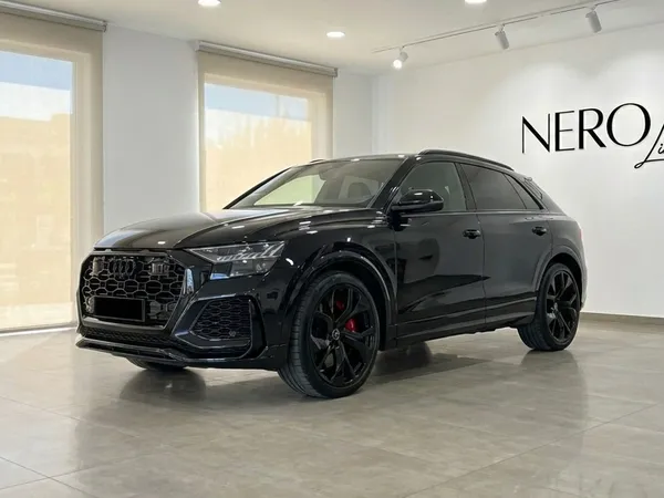 The black 2025 Audi RSQ8 is showcased from a front three-quarter angle in a bright showroom in Madrid.