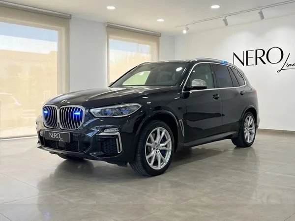 マドリードのショールームに駐車された、グリルとルーフに青い緊急灯を備えた黒いBMW X5 M装甲SUV。