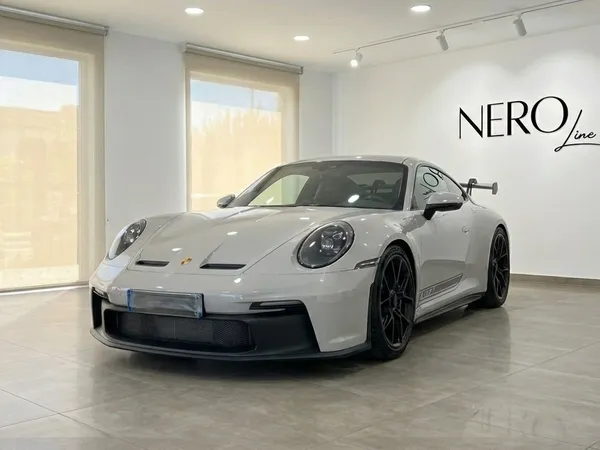 白いポルシェ911 GT3 992が、イビサのモダンなショールームで前方斜めから展示されています。