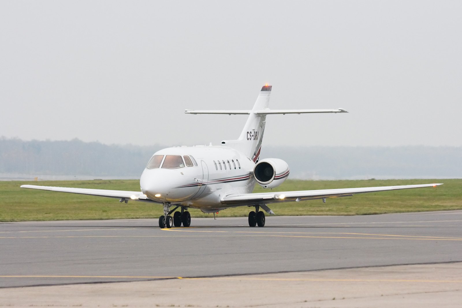 Hawker 800XP — Ready for departure in Barcelona The Hawker 800XP private jet is seen from a front-three-quarter view on the tarmac at Barcelona airport, ready for departure.