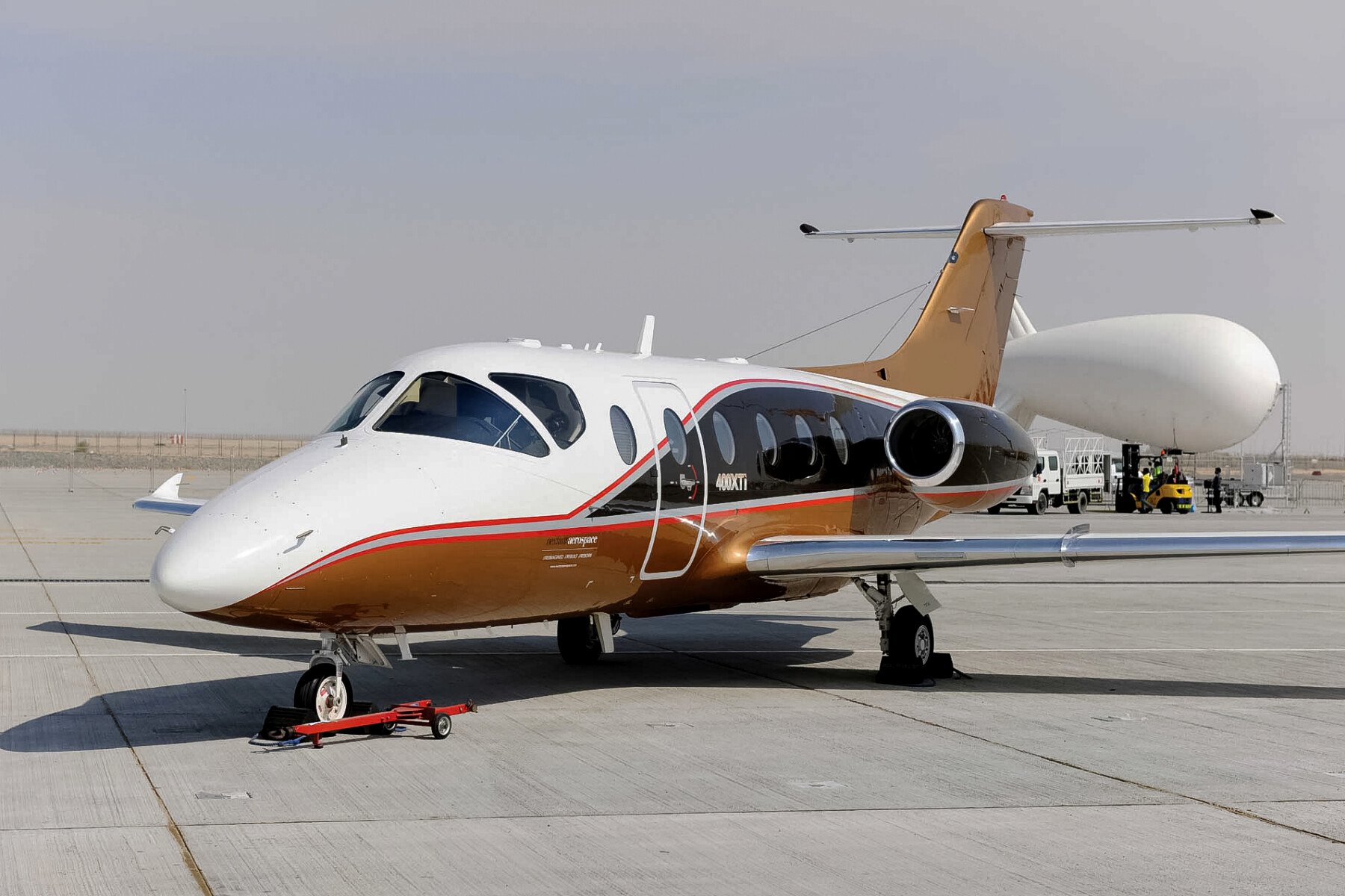 Nextant 400XTi — Exterior view on tarmac The Nextant 400XTi light jet, with its distinctive white and gold livery, parked on a sunlit tarmac in Marbella.