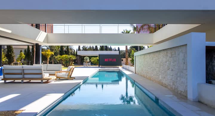 Die My Inner Peace Villa in Alicante bietet einen luxuriösen Außenbereich mit einem langen Pool, Loungemöbeln und einem großen Netflix-Bildschirm.