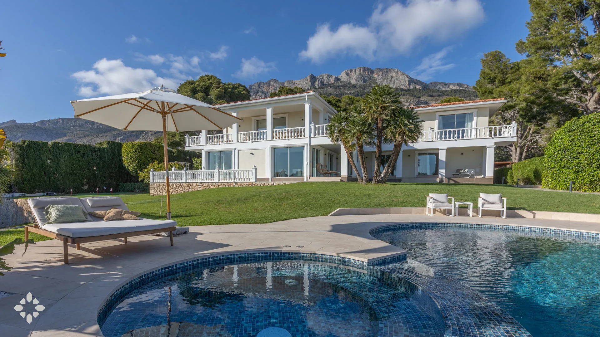 VILLA GOLF — Luxuriöses Äußeres mit Pool und Bergblick Das luxuriöse Äußere der VILLA GOLF bietet einen funkelnden Pool, üppigen Rasen und atemberaubende Bergblicke in Altea, Spanien.
