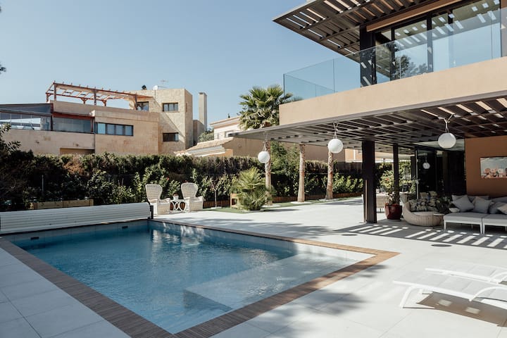 Das moderne Äußere der Villa Juana bietet einen privaten Außenpool, Sonnenliegen und einen schattigen Loungebereich in Alicante, Spanien.