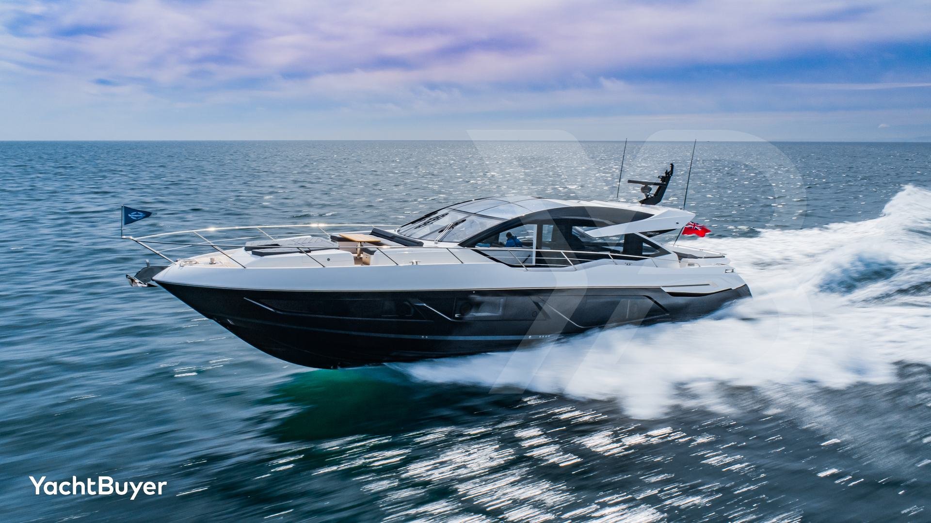 Die elegante Motoryacht Sunseeker Predator 74 durchpflügt das blaue Wasser und erzeugt weiße Gischt, während sie schnell fährt.