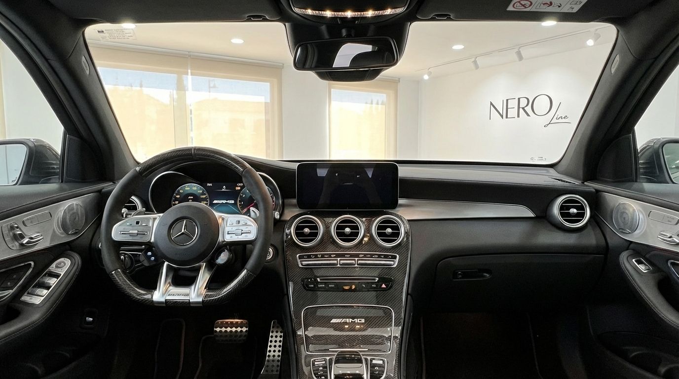 The luxurious cockpit of the Mercedes-Benz GLC 63 S AMG in Alicante, featuring the steering wheel, digital display, and carbon fiber trim.