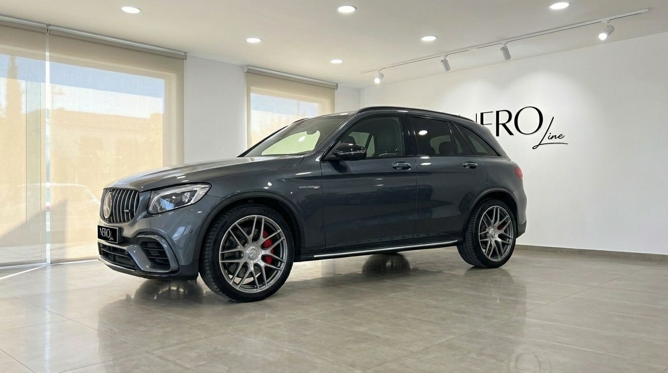 The metallic gray Mercedes-Benz GLC 63 S AMG is showcased from a front-side angle in a modern showroom in Alicante.