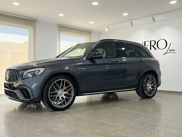 Mercedes-Benz GLC 63 S AMG — Showroom Alicante The metallic gray Mercedes-Benz GLC 63 S AMG is showcased from a front-side angle in a modern showroom in Alicante.