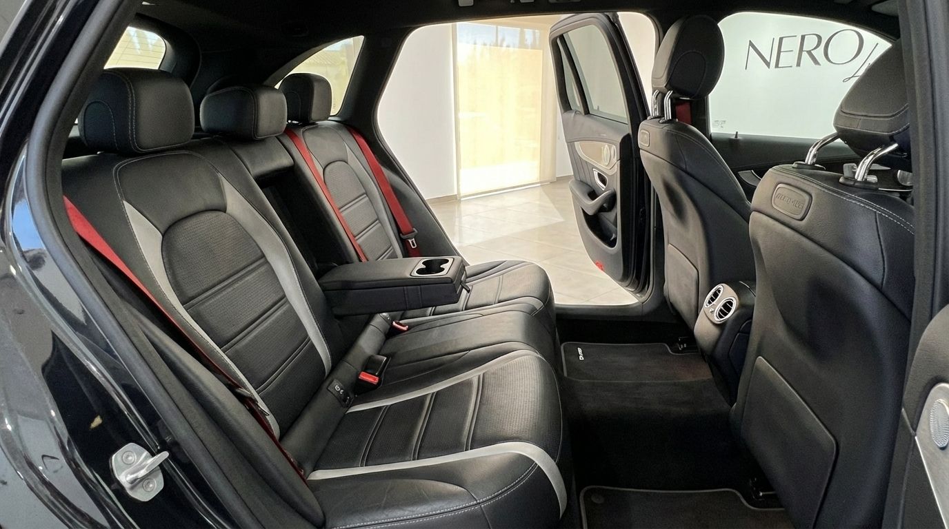 The rear interior of the Mercedes-Benz GLC 63 S AMG in Alicante, showcasing black leather seats with grey accents and red seatbelts.