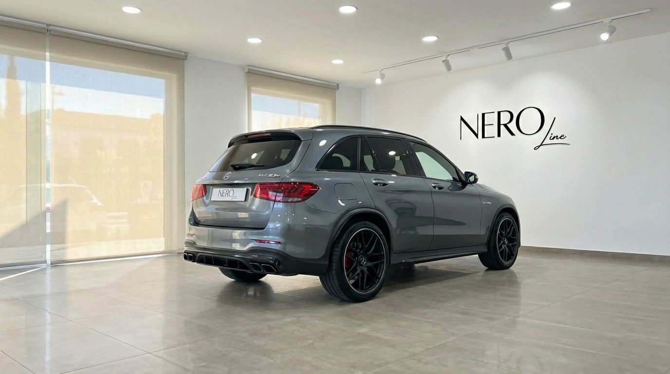 The metallic gray Mercedes-Benz GLC 63 S AMG is parked at a rear three-quarter angle in a showroom in Alicante.
