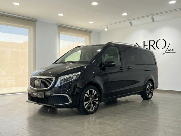Mercedes-Benz V250d — Furgoneta de Lujo en Madrid Una elegante furgoneta de lujo Mercedes-Benz V250d negra está estacionada en un showroom, vista desde tres cuartos delanteros en Madrid.