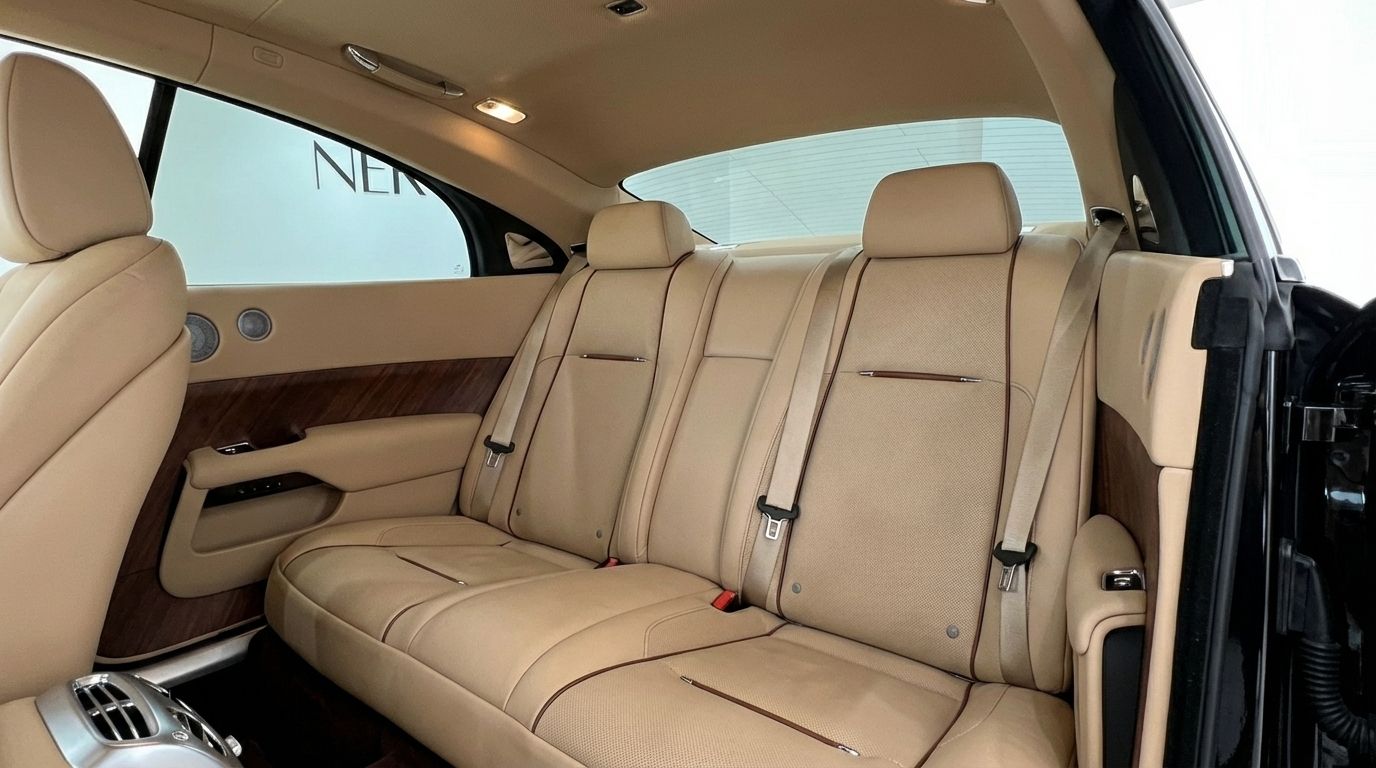 The luxurious beige leather rear seats and elegant wooden trim of the Rolls-Royce Wraith interior are visible in Malaga.