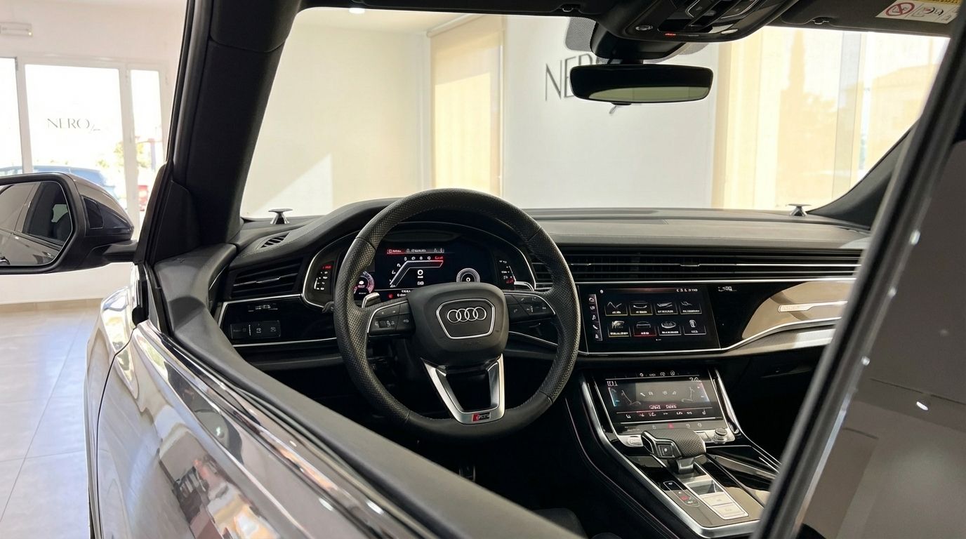 The luxurious cockpit of the Audi RS Q8 in metallic gray, featuring the steering wheel, digital displays, and center console, located in Alicante.