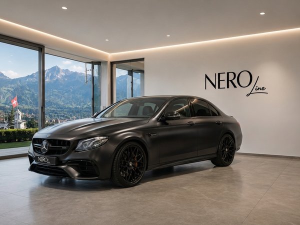 Mercedes-Benz E63S AMG — Zurich Showroom A matte black Mercedes-Benz E63S AMG sedan is parked in a modern showroom with a view of the Swiss Alps in Zurich.