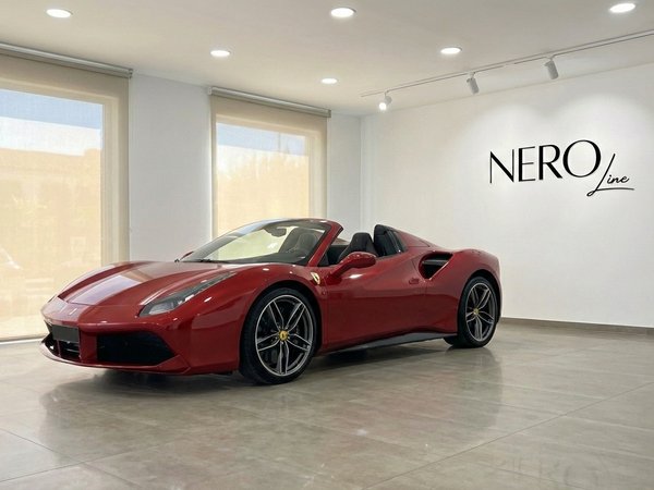 Ferrari 488 Spider — Showroom display Alicante The racing red Ferrari 488 Spider convertible is prominently displayed in a modern showroom in Alicante, showcasing its sleek design.