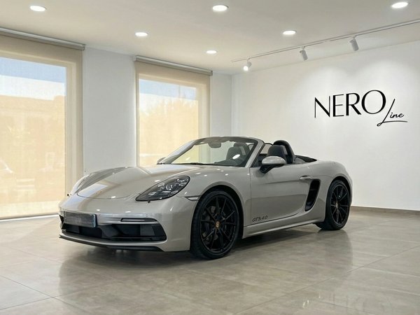 Porsche 718 Boxster 4.0 GTS — Luxury Convertible The metallic silver Porsche 718 Boxster 4.0 GTS convertible is parked in a showroom in Marbella, showcasing its sleek design.