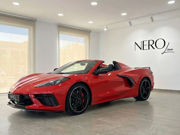 Chevrolet Corvette Stingray C8 — Red convertible The red Chevrolet Corvette Stingray C8 convertible is parked indoors at a showroom in Alicante, showcasing its sleek design.