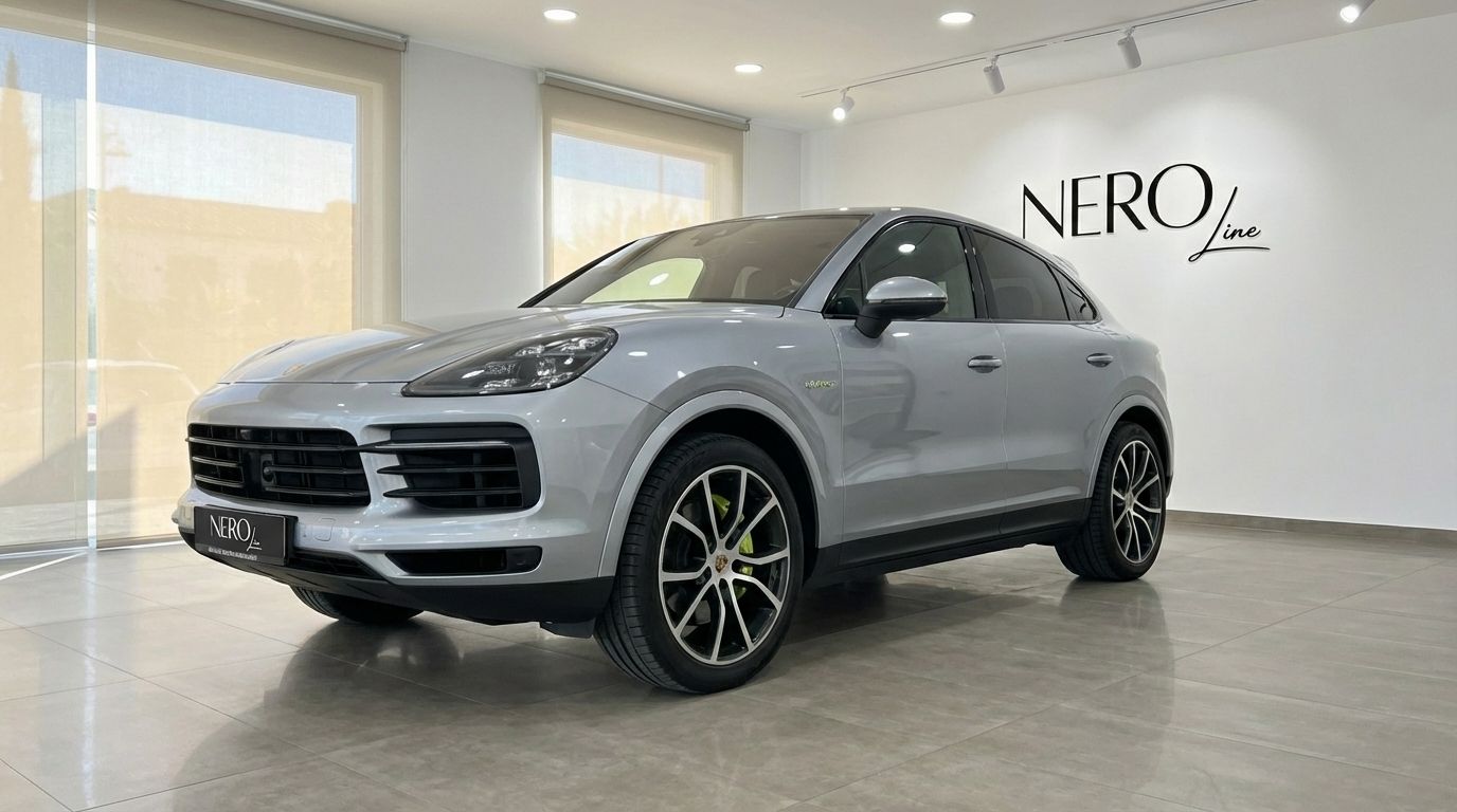 A silver 2024 Porsche Cayenne Coupe is parked indoors, showcasing its front three-quarter view in Marbella.