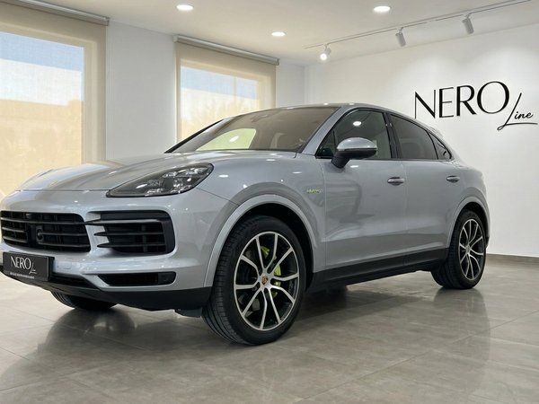 Porsche Cayenne Coupe — Silver, indoor view A silver 2024 Porsche Cayenne Coupe is parked indoors, showcasing its front three-quarter view in Marbella.