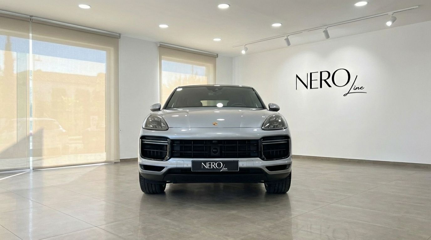 Front view of the silver metallic 2024 Porsche Cayenne Coupe displayed in a bright Nero Line showroom in Marbella.