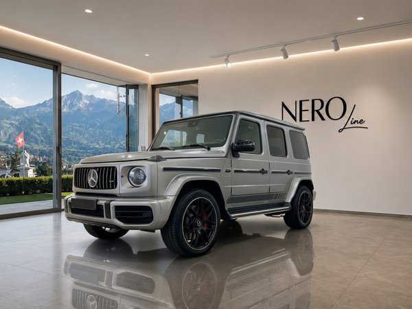 Mercedes G63 Grau — Luxury SUV in Zurich The Mercedes G63 Grau, a matte silver luxury SUV, is parked in a modern Zurich showroom with a panoramic mountain view.
