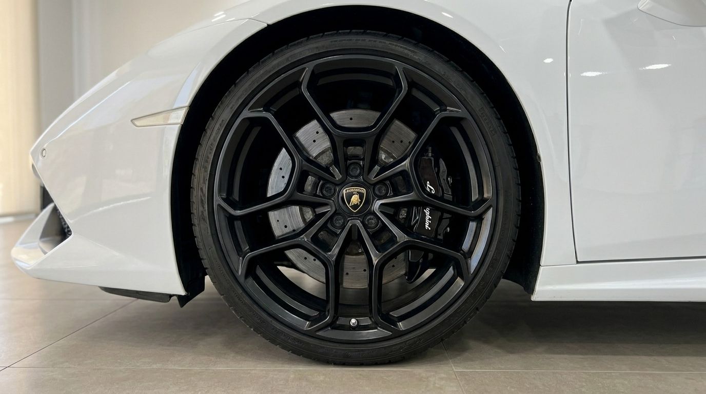 The white Lamborghini Huracan Spyder LP610-4's front wheel, showcasing its black multi-spoke rim and brake caliper in Alicante.