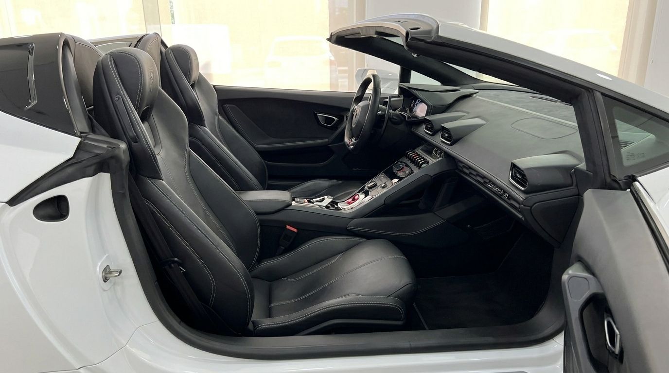 White Lamborghini Huracan Spyder LP610-4 interior, showing black leather seats, dashboard, and steering wheel from the driver's side in Alicante.