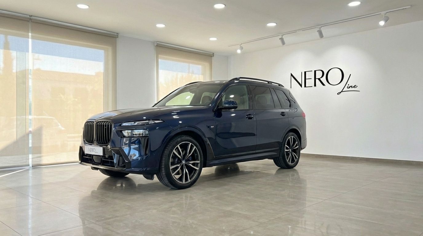 El SUV de lujo BMW X7 xDrive 2023 azul oscuro está aparcado en una sala de exposición en Alicante, mostrando su elegante vista frontal tres cuartos.