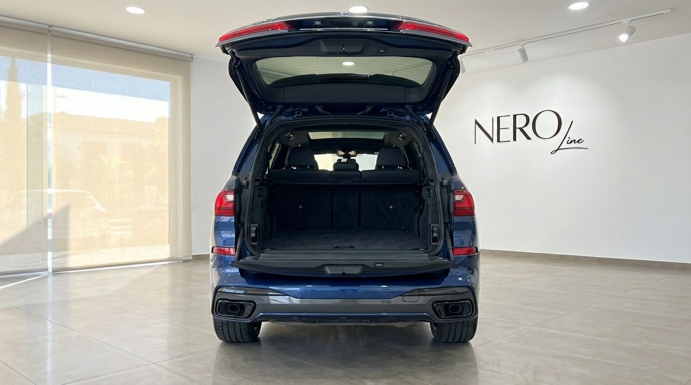 El BMW X7 xDrive 2023 azul oscuro se muestra desde la parte trasera con su espacioso maletero abierto, aparcado en Alicante.