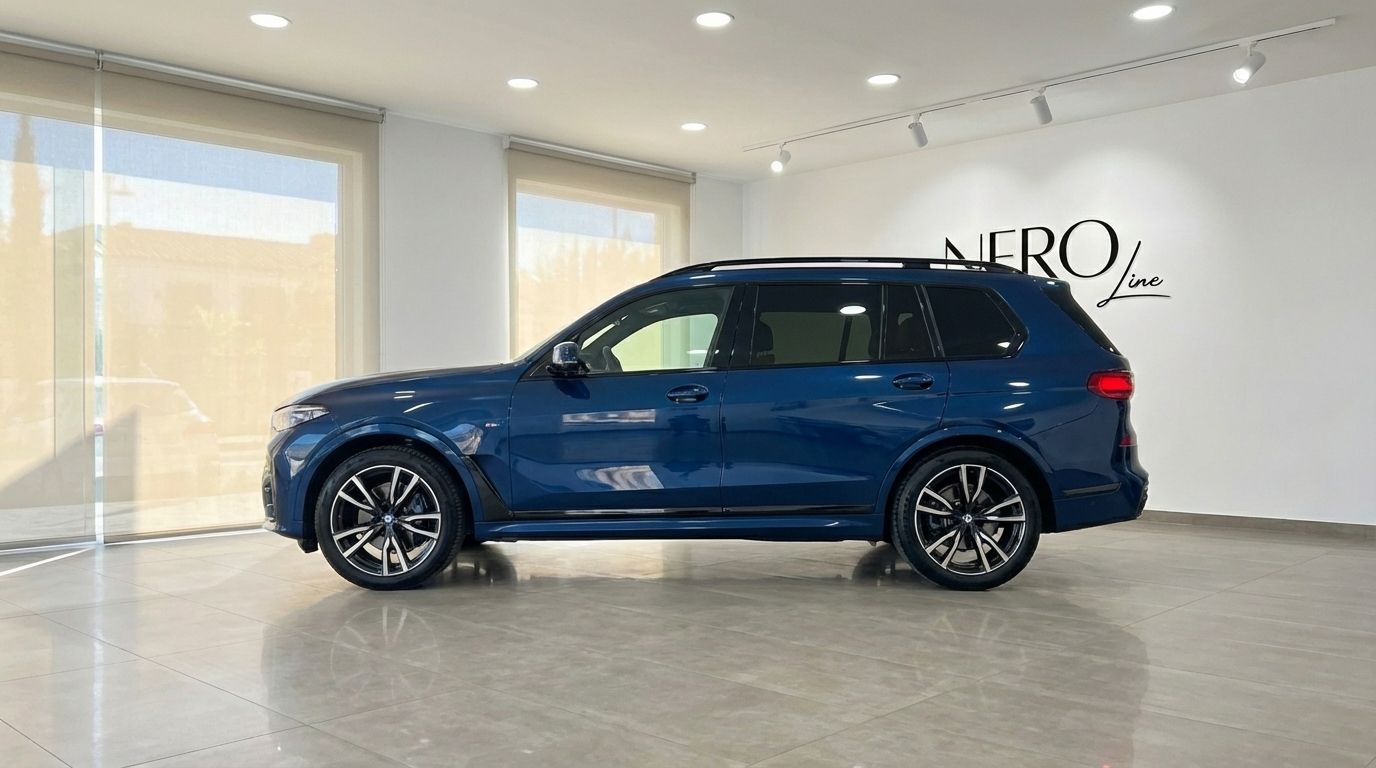 El BMW X7 xDrive 2023 azul oscuro se exhibe en un concesionario, visto de perfil elegante en Alicante.