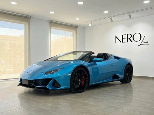 Lamborghini Huracan Evo Spyder — Marbella showroom The metallic blue Lamborghini Huracan Evo Spyder convertible, with its top down, is showcased in a Marbella showroom.