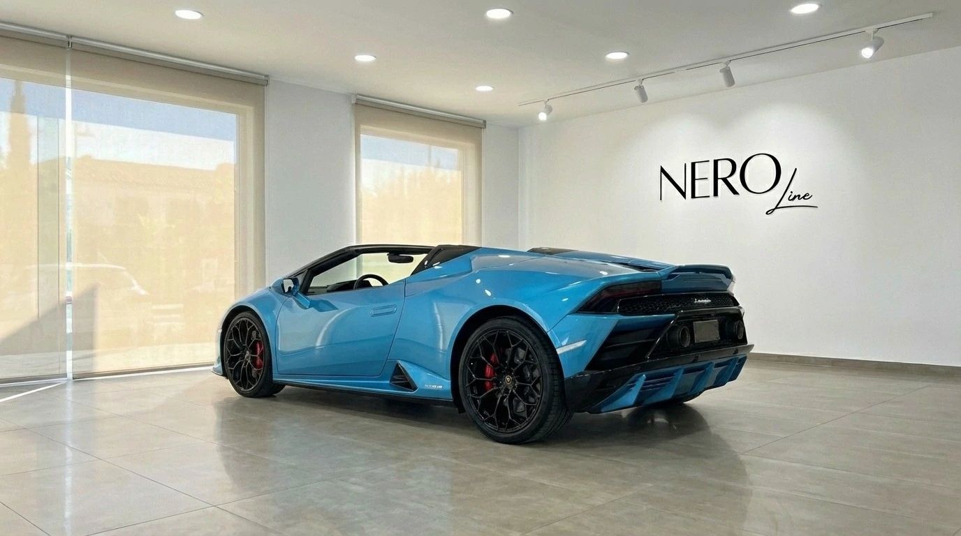 The metallic blue Lamborghini Huracan Evo Spyder is showcased from a rear three-quarter angle in a bright showroom in Marbella.