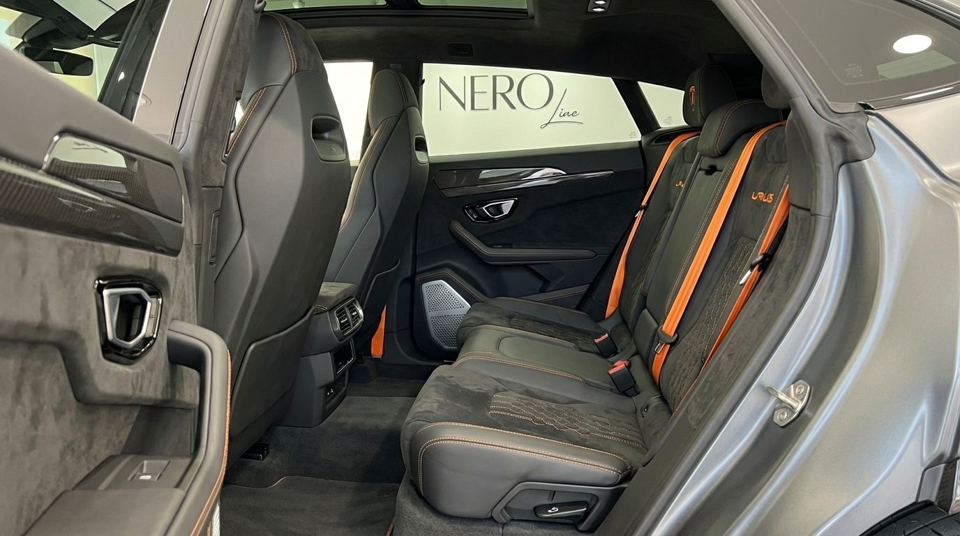 El interior trasero del Lamborghini Urus Performante en Madrid, con asientos deportivos negros y detalles y cinturones naranjas.